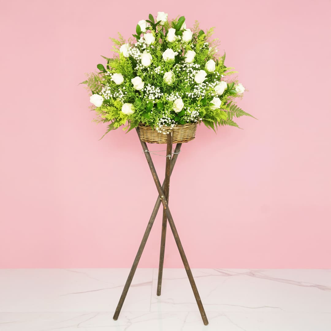May God Bless You An arrangement of white roses on a stylish stand, showcasing their beauty.