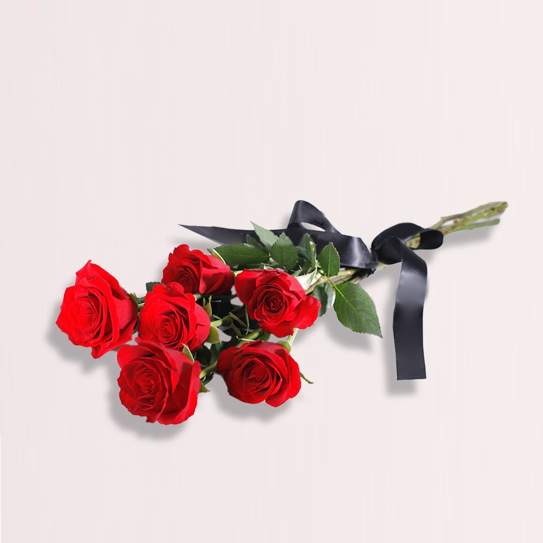 1 A hand-tied bouquet of six red rose stems elegantly wrapped with a black ribbon.