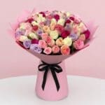 A vibrant pink bouquet featuring a mix of purple and pink roses arranged elegantly.