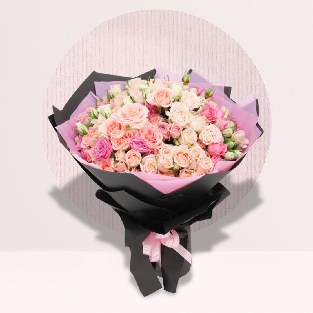 1 (34) Hand bouquet of 30 mixed spray roses in pink, peach, cream and blush shades with black and pink wrapping.