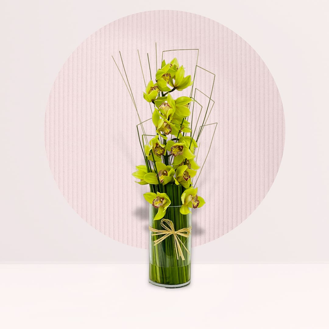 Flowers With Vase Yellow cymbidium orchid arrangement in tall glass vase with decorative foliage