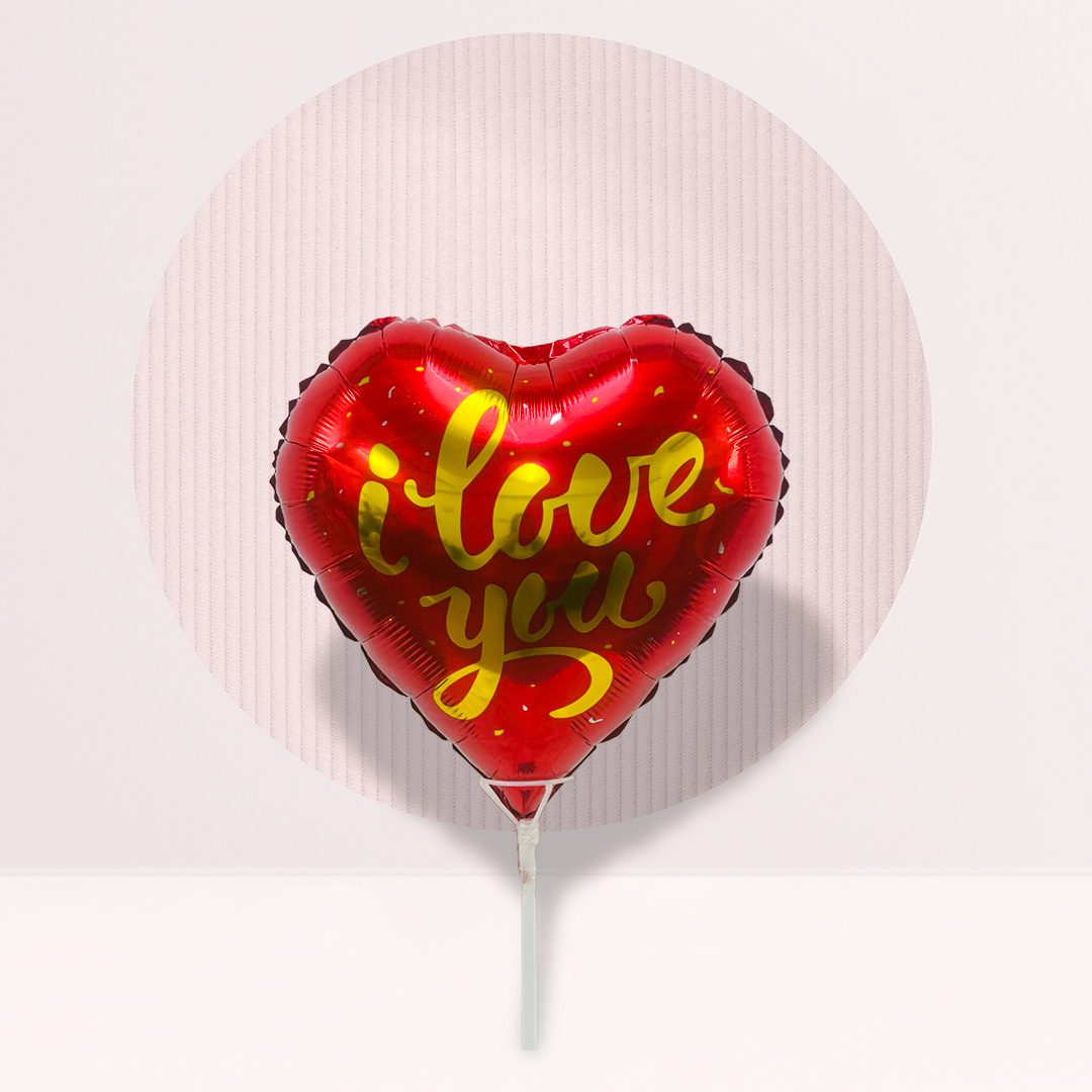 IMG_1259 Red heart-shaped foil balloon with gold "I Love You" script text, mounted on a stick, pink background