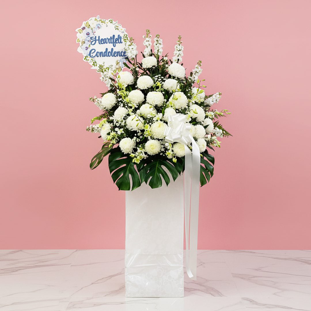 Healing Grace A white stand filled with white flowers with a Heartfelt Condolence sign.