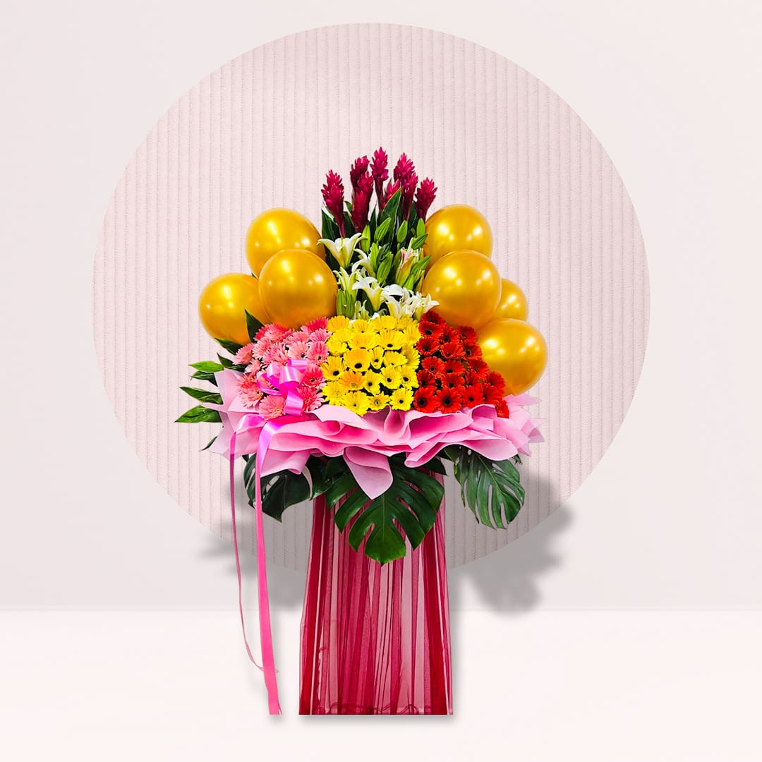 41 Golden Celebration grand opening flower stand with colourful flowers, tropical leaves and gold balloons