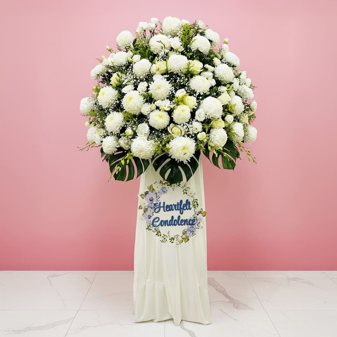 Graceful Sympathy A white funeral flower arrangement beside a sign that reads "Heartfelt Condolence," conveying a heartfelt message.