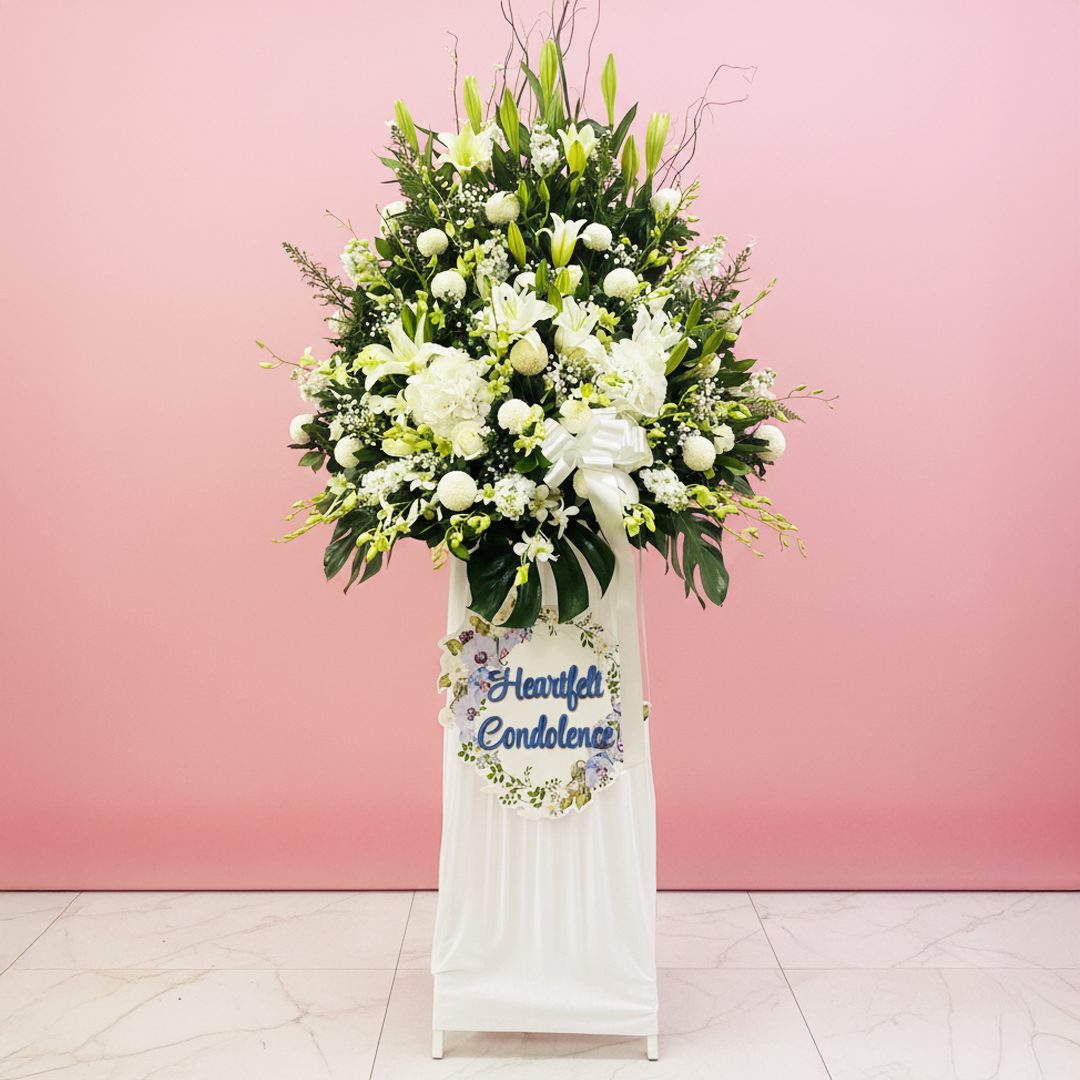 Soothing Condolence Floral Display A white stand filled with white flowers beside a sign that reads "Heartfelt Condolence"