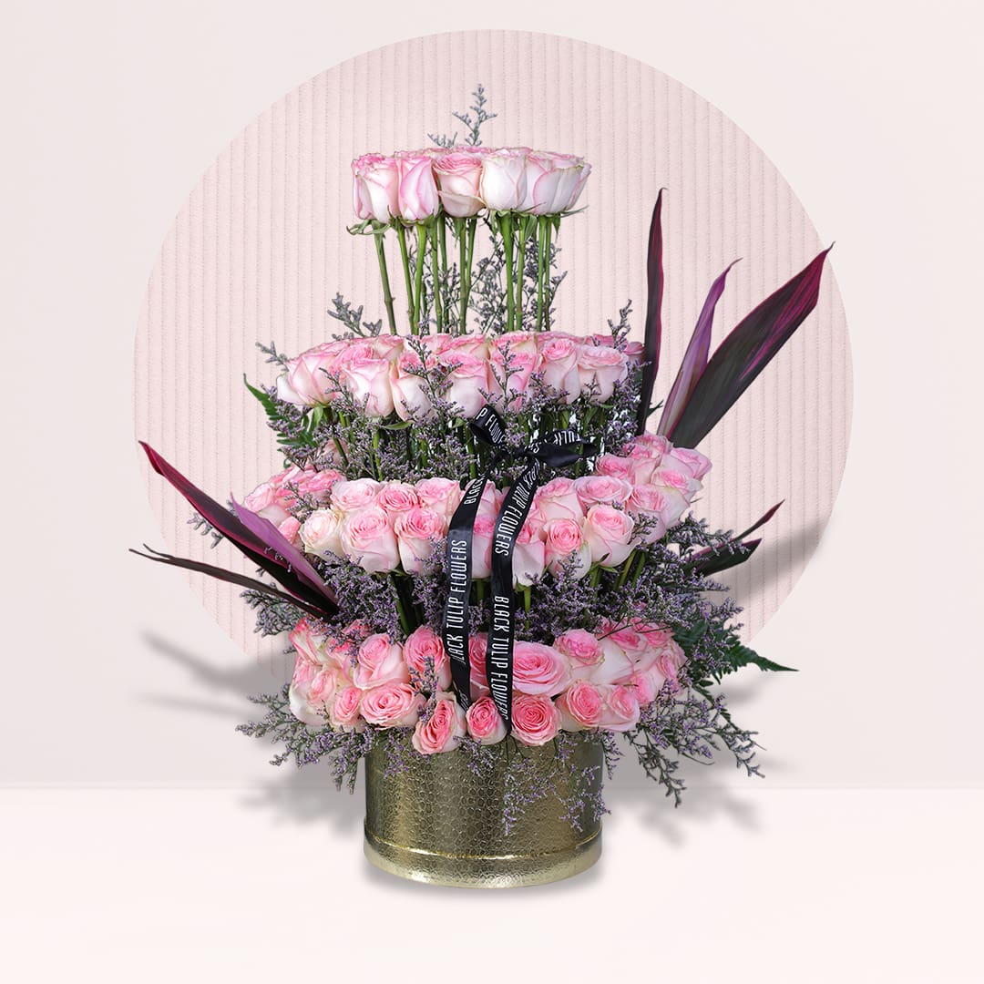 1 Tiered pink rose flower arrangement with purple fillers in gold round box