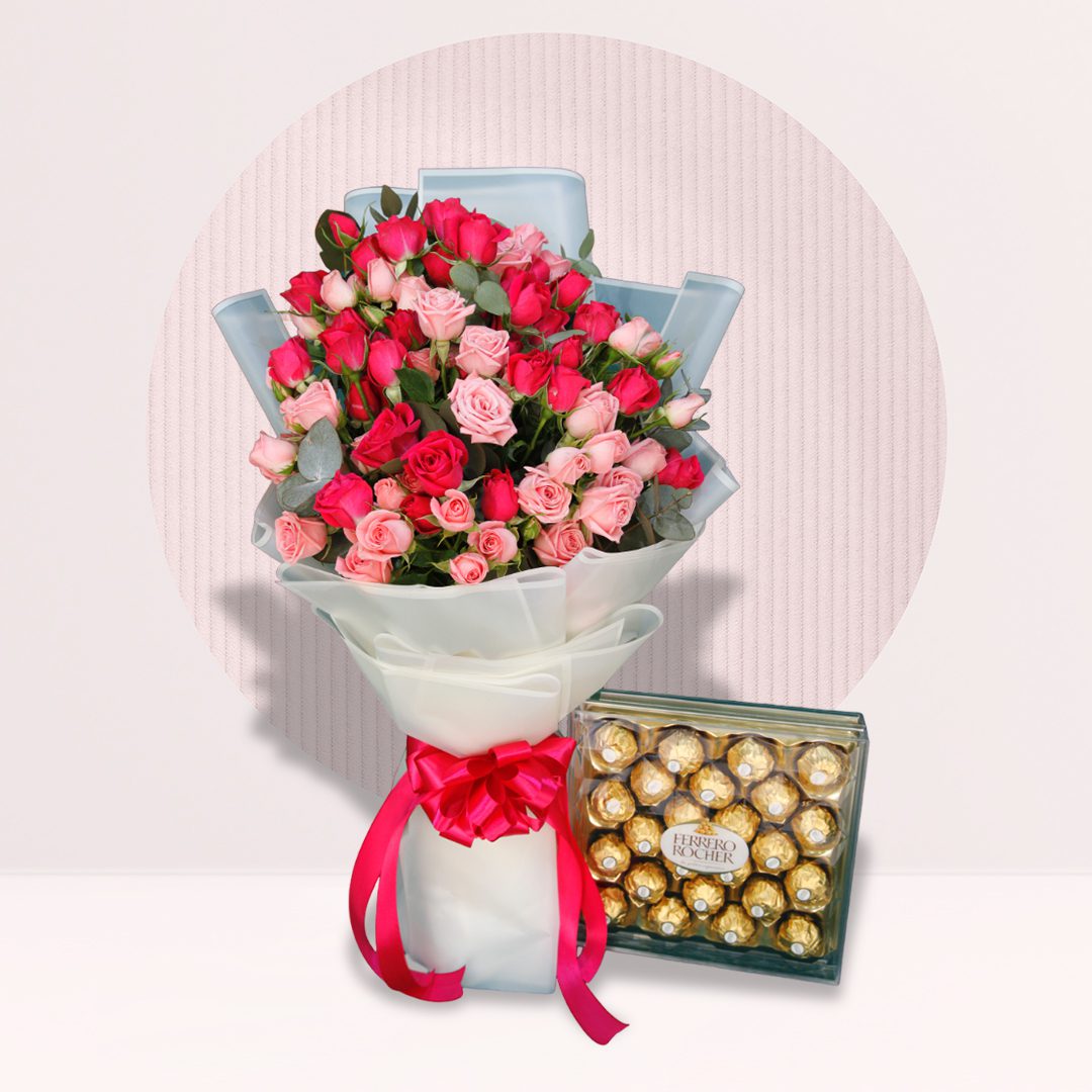 A bouquet of pink and red roses with a box of Ferrero Rocher chocolates.