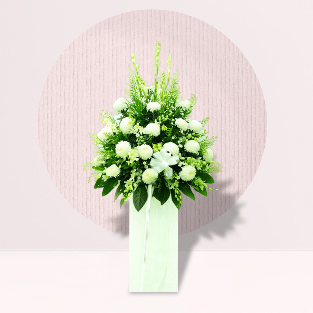 White Flowers: The arrangement predominantly features white flowers, including what appear to be chrysanthemums or similar rounded blooms. White is often associated with purity, peace, and remembrance.
