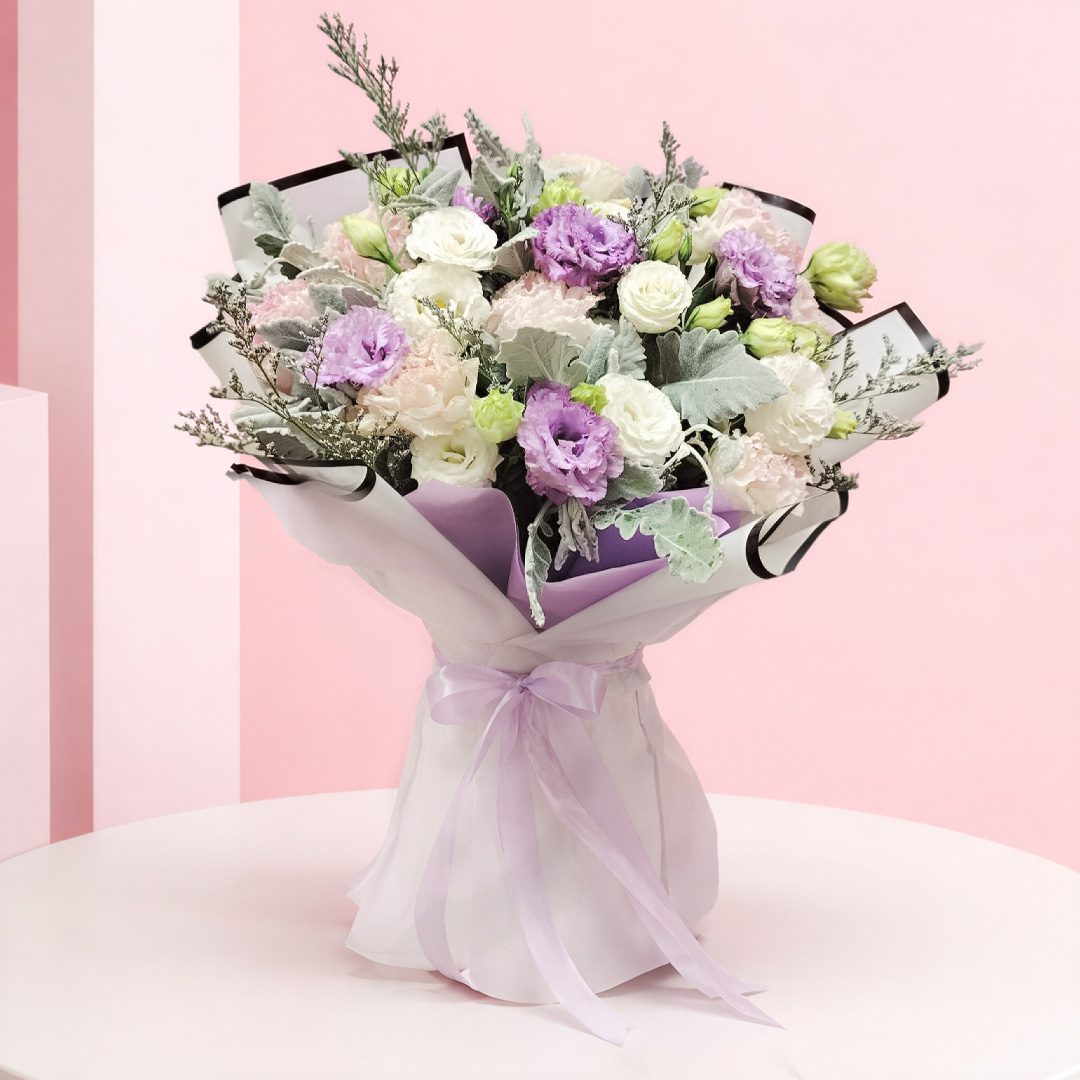 01 Handheld pastel flower bouquet with lavender whisper, white, and blush blooms wrapped in elegant paper with ribbon.