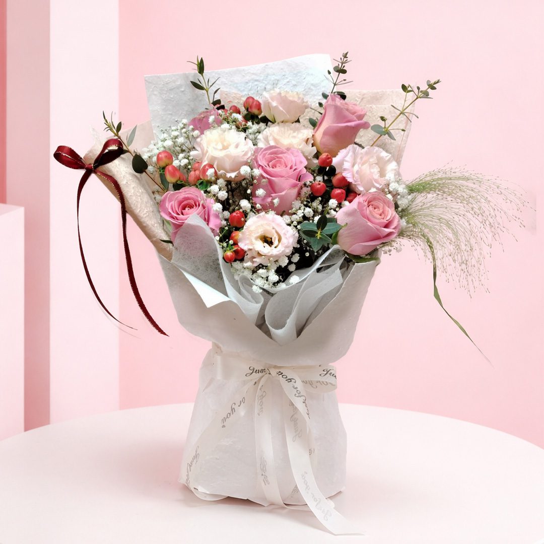 01 pink rose charm bouquet with pink roses, , baby’s breath and greenery in premium neutral wrapping, finished with an elegant ribbon bow.