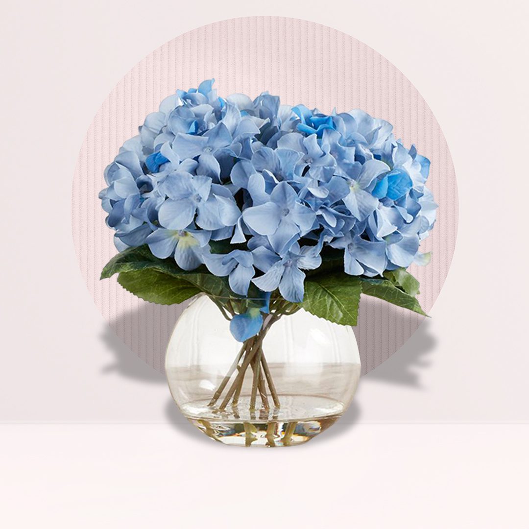 A vase filled with vibrant blue flowers, elegantly arranged against a neutral background.