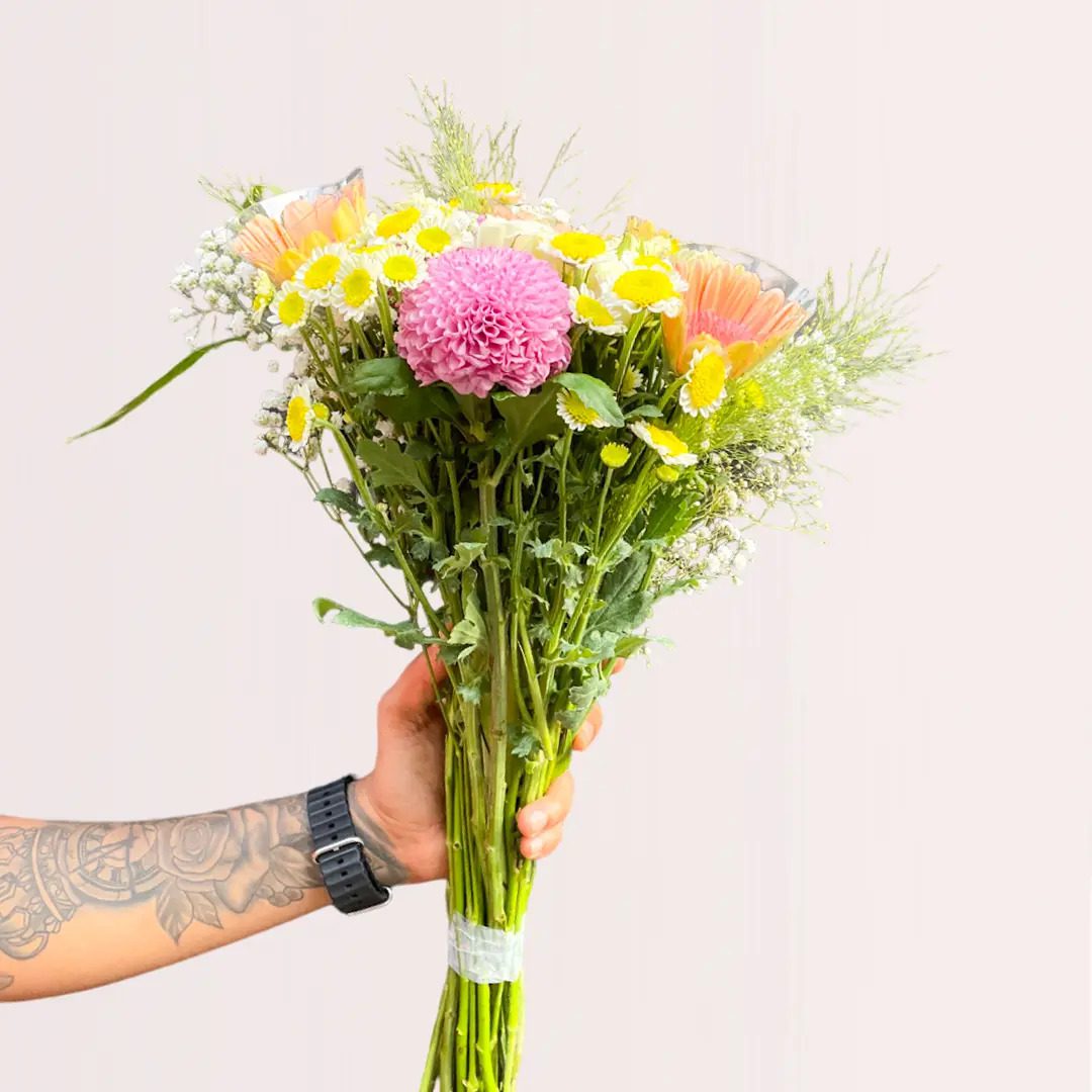 Person presenting a vibrant floral arrangement.