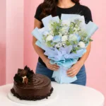 Chocolate Mousse & Flowers Combo featuring a hand bouquet of blue roses and seasonal flowers paired with a Belgian chocolate mousse chiffon cake for gifting and celebrations.