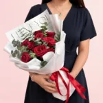 Crimson Love Rose Bouquet featuring fresh red roses and eucalyptus arranged in a dramatic and elegant floral design.