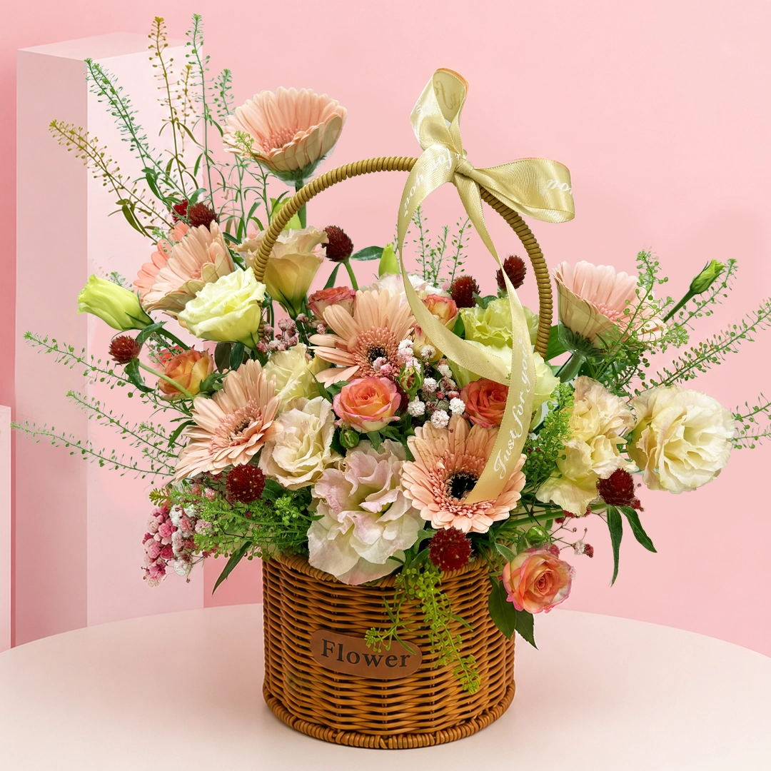 soft-peach-flower-basket 6 peach gerberas, delicate spray rose, lisianthus bloom, gomphrena flowers, seasonal fillers, and foliage arranged in a premium woven basket.