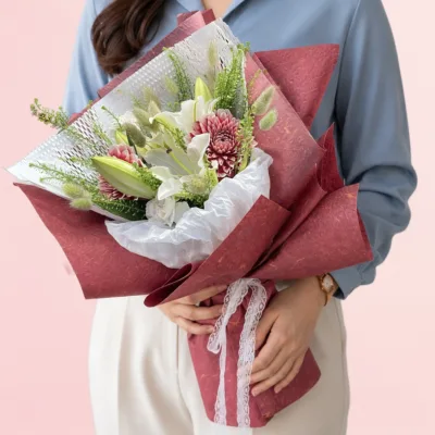 Fresh oriental white lilies and white lisianthus complemented by pink anastasia in a beautifully handcrafted bouquet.
