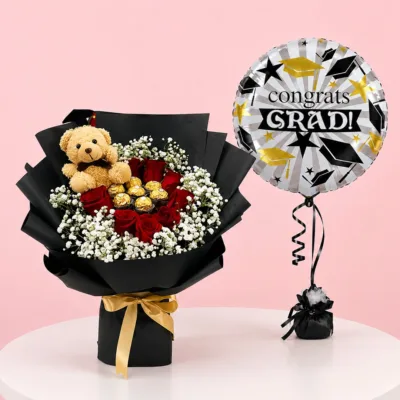 Graduation arrangement with roses, Ferrero Rocher, teddy bear, and a 'Congrats Grad' balloon