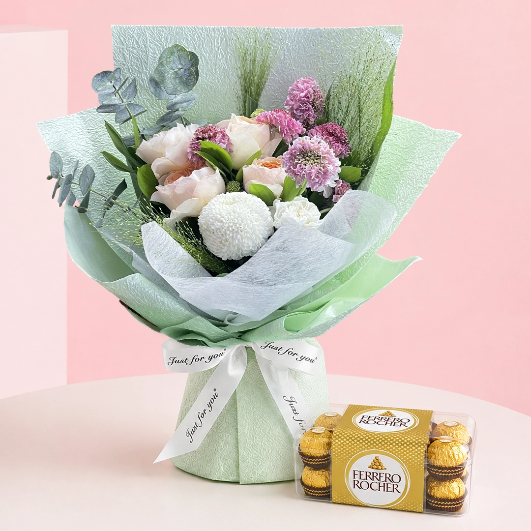 peach-rose-bouquet-with-ferrero-rocher Peach roses, white ping pong, and carnation flowers with fillers wrapped in a green sheet, paired with Ferrero Rocher hazelnut chocolates