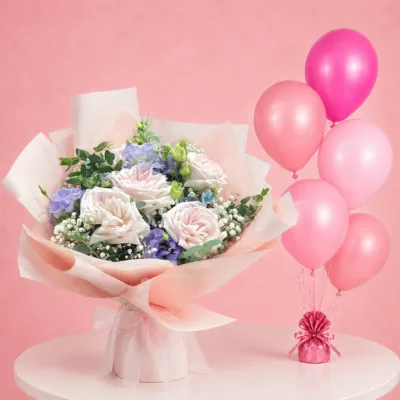 5 light pink roses, 2 purple lisianthus arranged with baby’s breath, mixed greens, and 5 colourful balloons
