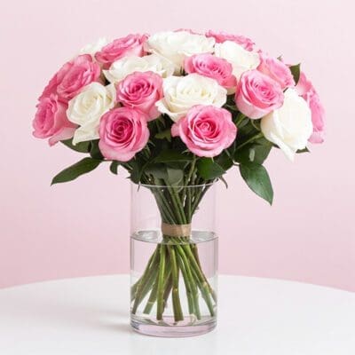 A vase filled with pink and white roses, showcasing a vibrant floral arrangement.