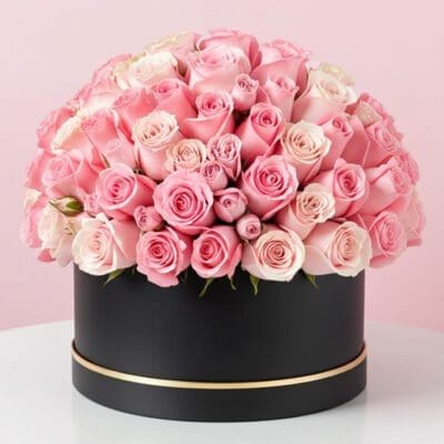 A large black box filled with vibrant pink roses, showcasing a beautiful floral arrangement.