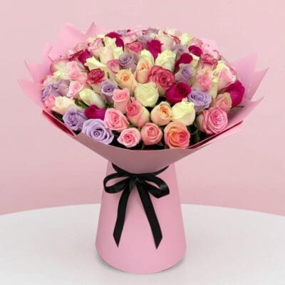 A vibrant pink bouquet featuring a mix of purple and pink roses arranged elegantly.