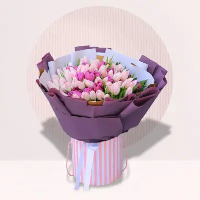 Hand bouquet of two coloured tulips in elegant wrapping.