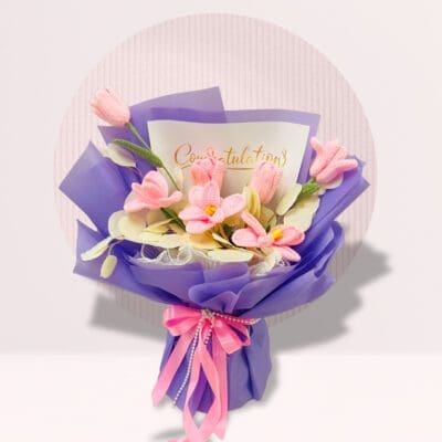Hand bouquet of pink tulips with decorative crochet accents.
