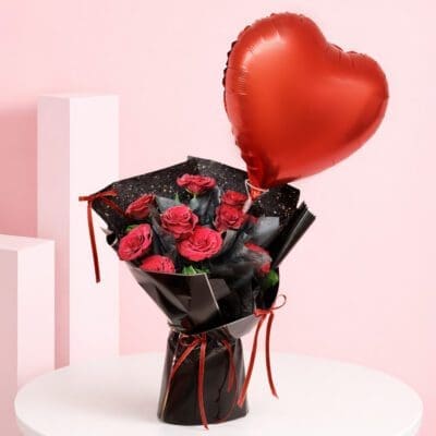 Romantic red roses with heart balloon bouquet wrapped in black paper with red ribbons and a red heart-shaped balloon