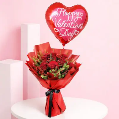 Red rose valentine balloon bouquet with seasonal fillers and greens in premium red wrapping, with a Happy Valentine’s Day heart balloon message