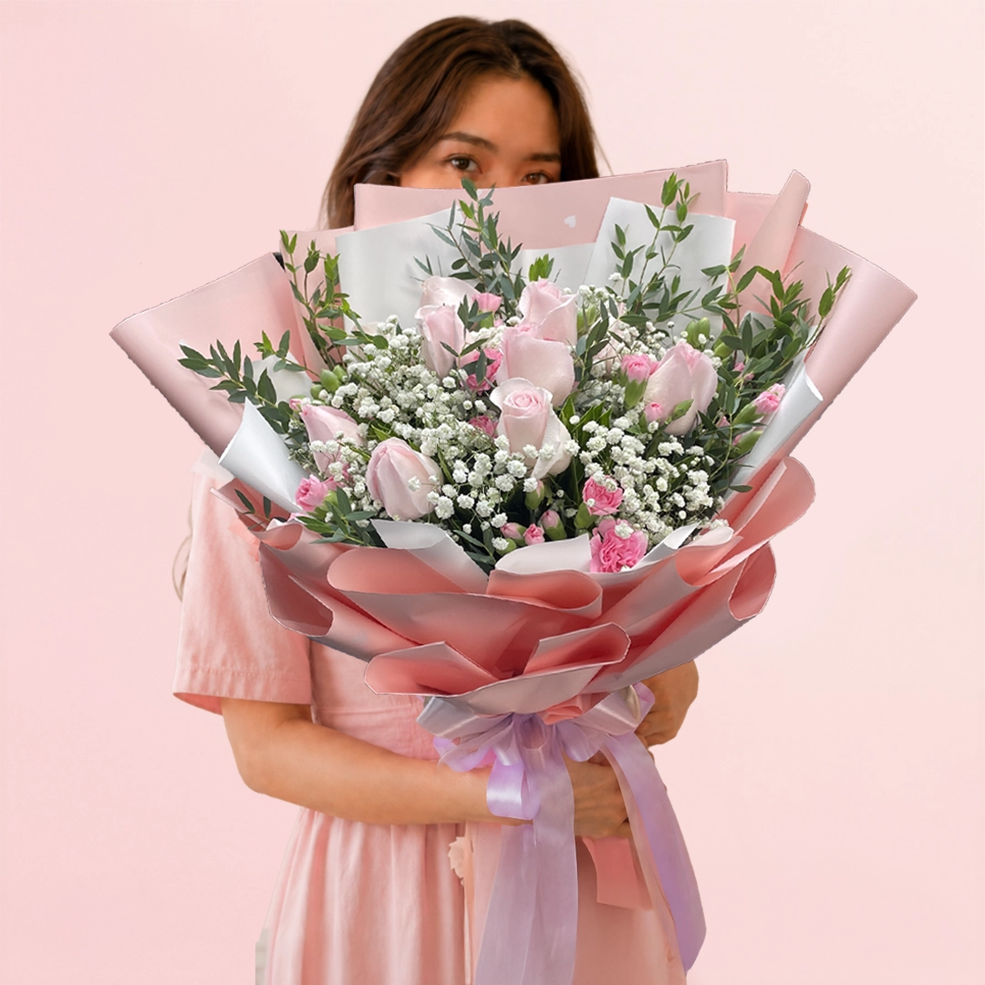blushing-beauty-bouquet Pastel Dream Bouquet featuring pink roses, pink spray carnations, gypsophila, and ruscus leaves arranged in a romantic and elegant floral design.