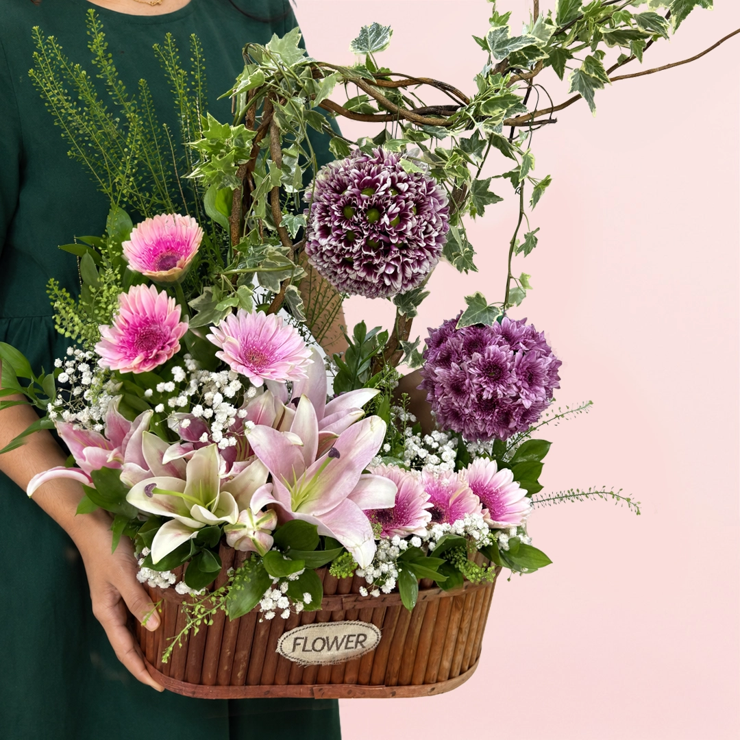 purple-chrysanthemum-gerbera-basket_01 Premium floral basket with vibrant chrysanthemums, soft pink gerberas, and an elegant lily for celebrations.